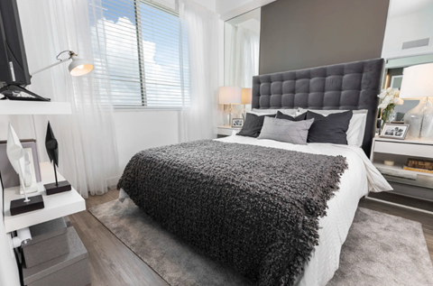 A modern bedroom with a large bed and a television.