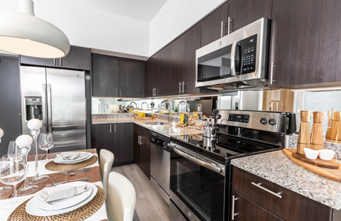 A modern kitchen with a dining table set for two.