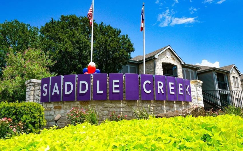 a sign for the saddle creek neighborhood in front of a house - Photo Gallery 1