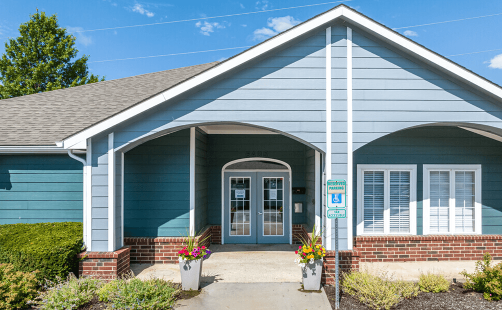 the front of a blue house with a blue door
