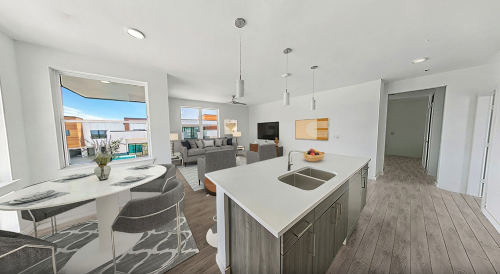 a kitchen and living room with a white counter top and a dining room table