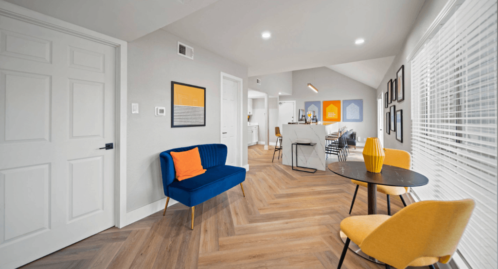 a living room with a table and chairs and a kitchen