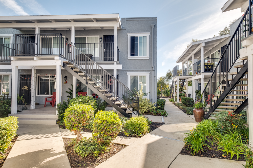 an exterior view of apartments with stairs and landscaped gardens