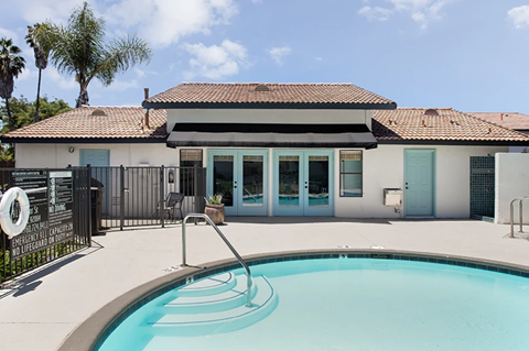 a swimming pool with a house in the background