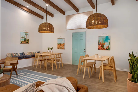 a living room with tables and chairs and a blue door