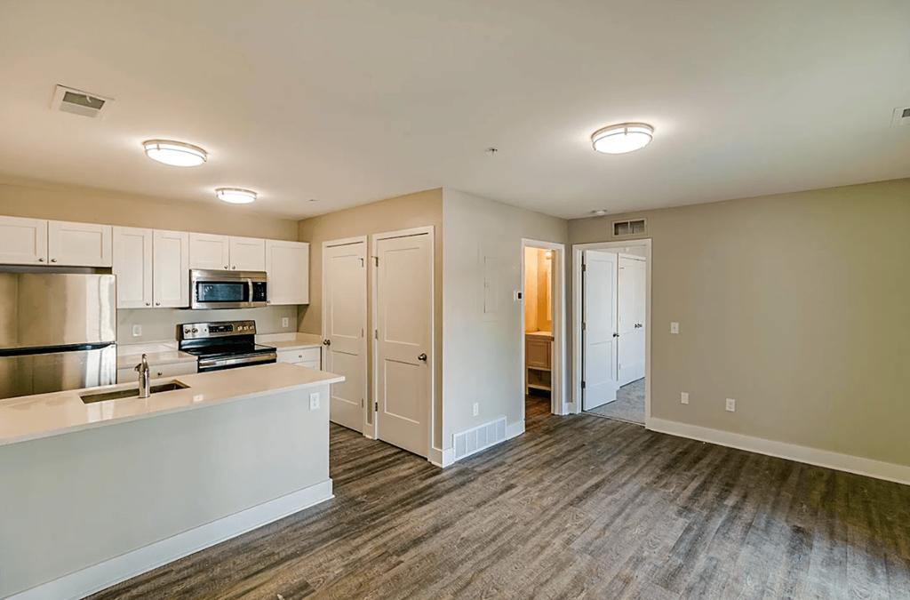 a kitchen with white cabinets and a sink and a refrigerator