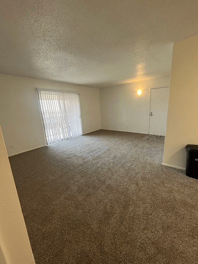 an empty living room with a sliding glass door