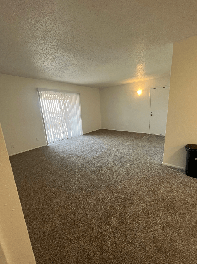 an empty living room with a sliding glass door