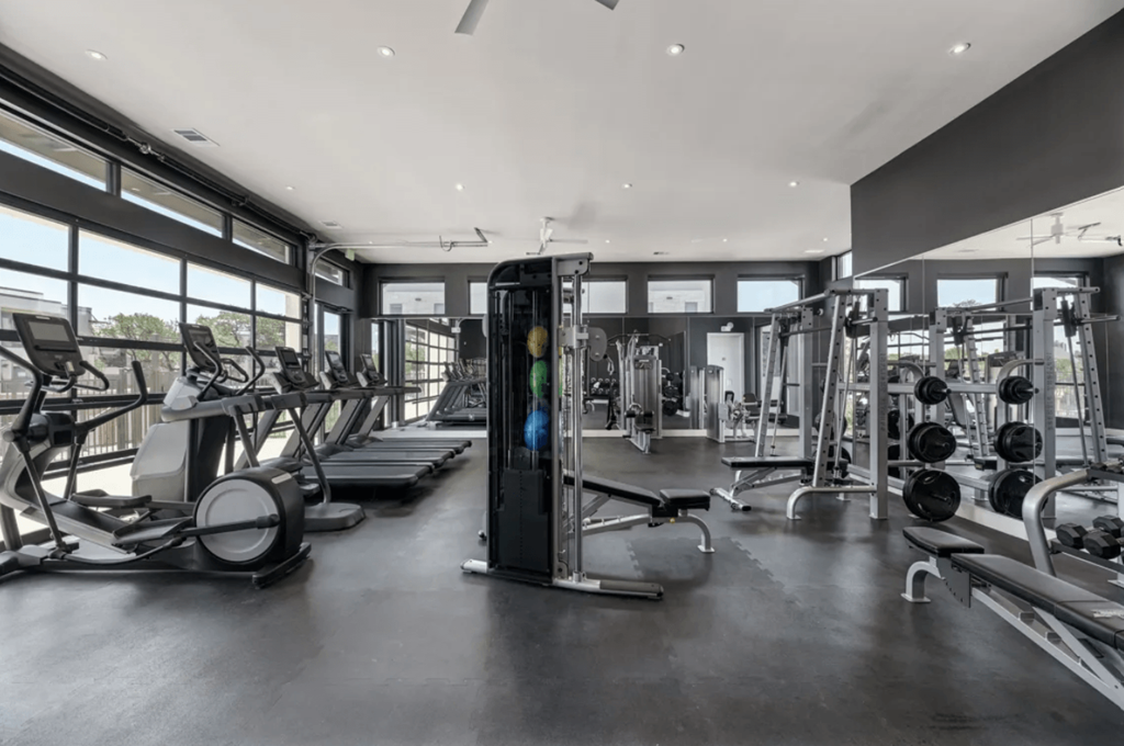 the gym has plenty of equipment and windows to the outdoors