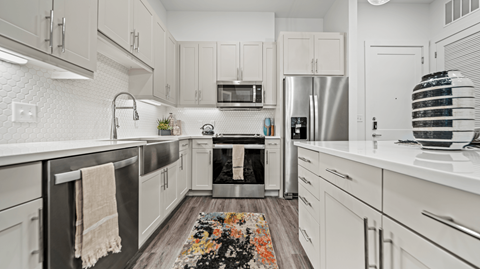 A modern kitchen with white cabinets and stainless steel appliances.