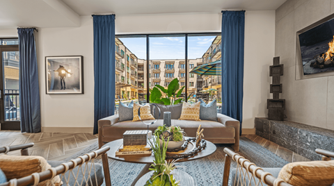A living room with a large window overlooking a cityscape.