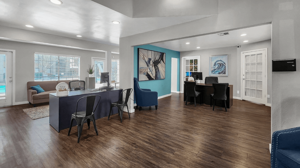 A modern living room with a blue accent wall and wooden flooring.