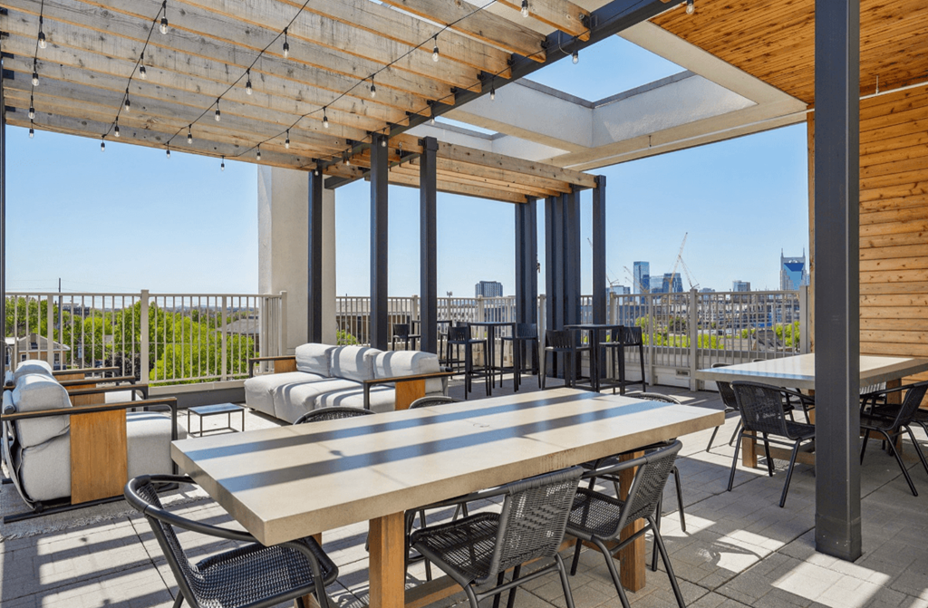 A patio with a table and chairs overlooking a city skyline.