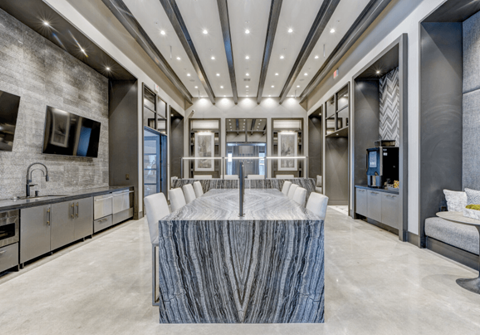 A modern kitchen with a marble table in the center.