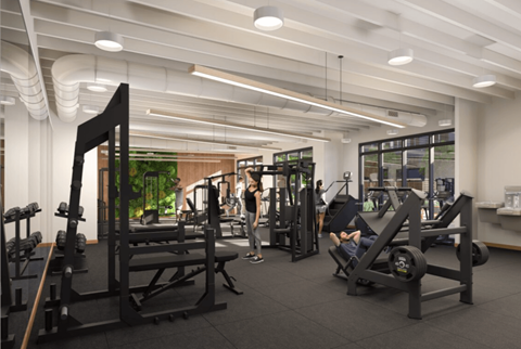 A gym with people working out and various equipment.