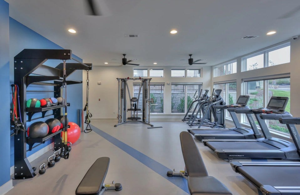 A spacious gym with treadmills, weights, and exercise equipment.