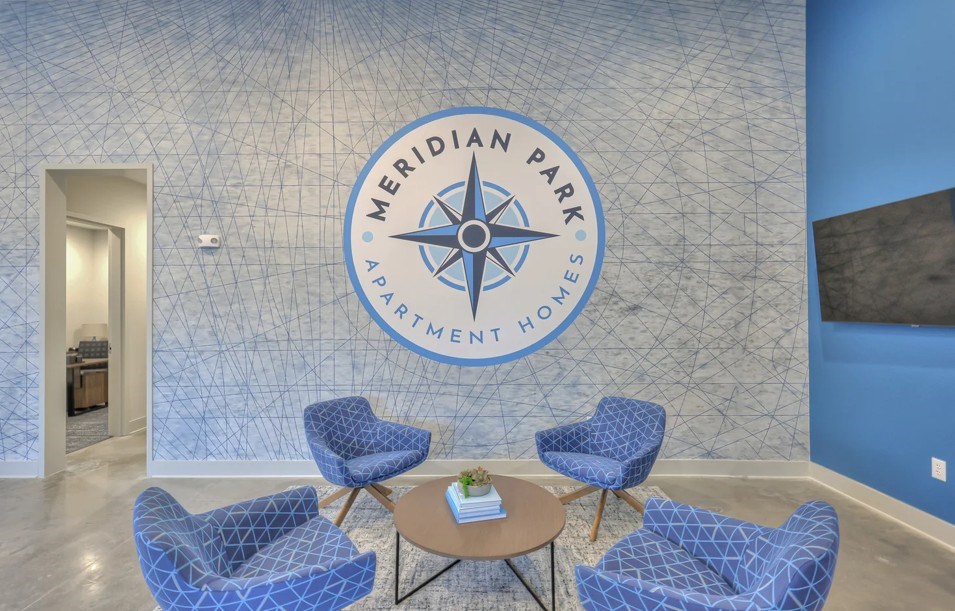 A blue and white wall with a compass design and Meridian Park Apartment Homes written on it.
