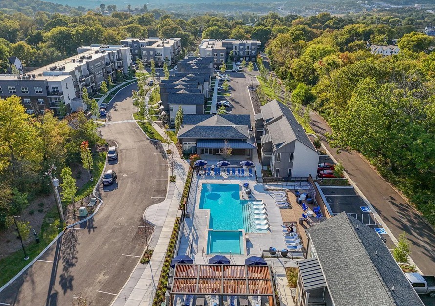 An aerial view of a residential area with a swimming pool and apartment buildings.