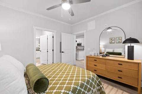 A bedroom with a bed, dresser, and mirror.