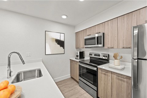 A kitchen with a white sink and a refrigerator.