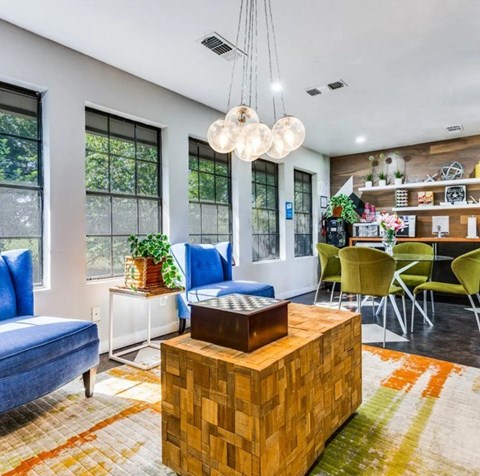 A living room with a blue couch, a wooden coffee table, and a rug with a geometric pattern.