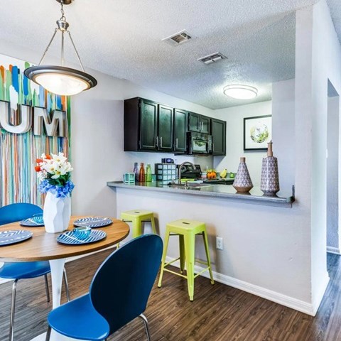 A kitchen with a table and chairs.