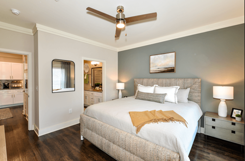 A bedroom with a bed, nightstands, and a ceiling fan.