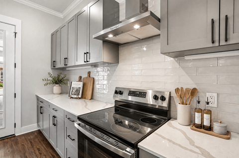 A modern kitchen with a stove top oven and a white counter top.