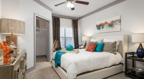 A bedroom with a large bed and a ceiling fan.