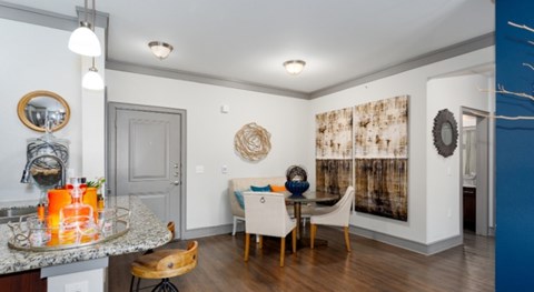 A dining room with a table set for two and a blue accent wall.