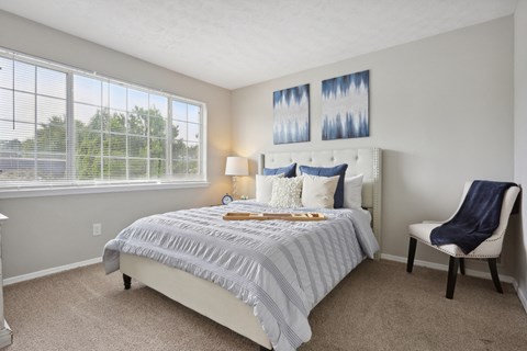 a bedroom with a bed and a chair