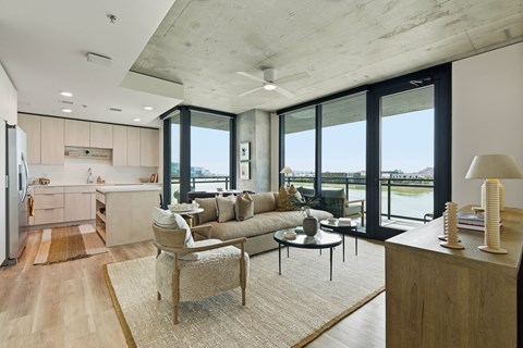 A modern living room with a couch, chair, and a table with a lamp on it.