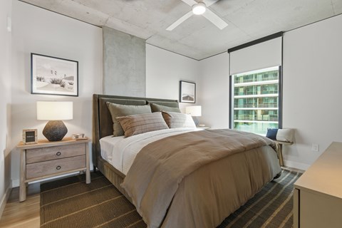 A bedroom with a large bed and a ceiling fan.