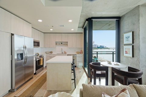 A modern kitchen with a refrigerator, stove, and dining table.