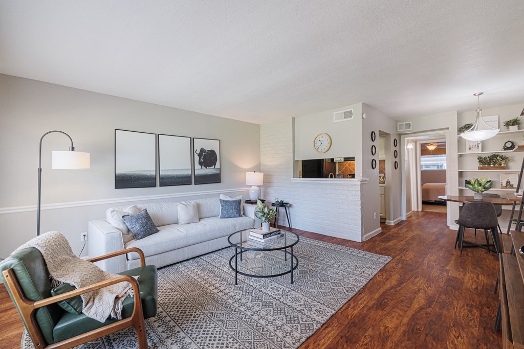 A living room with a white couch, a green chair, and a coffee table.