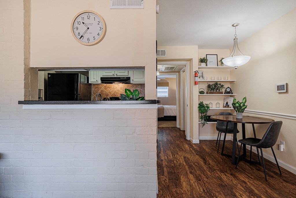 a dining area with a table and chairs and a fireplace with a clock on the wall