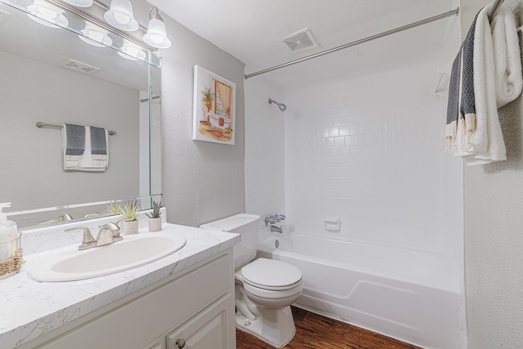 A white bathroom with a toilet, sink, and bathtub.