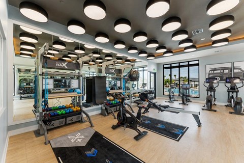 A gym with a variety of equipment including treadmills, weights, and exercise bikes.