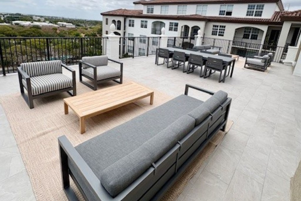 A patio with furniture and a house in the background.
