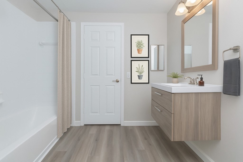A bathroom with a white door, a sink, and a mirror.