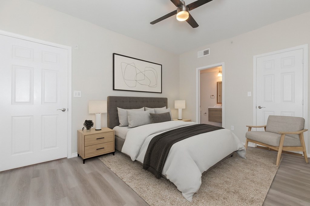 A bedroom with a bed, nightstand, and chair.