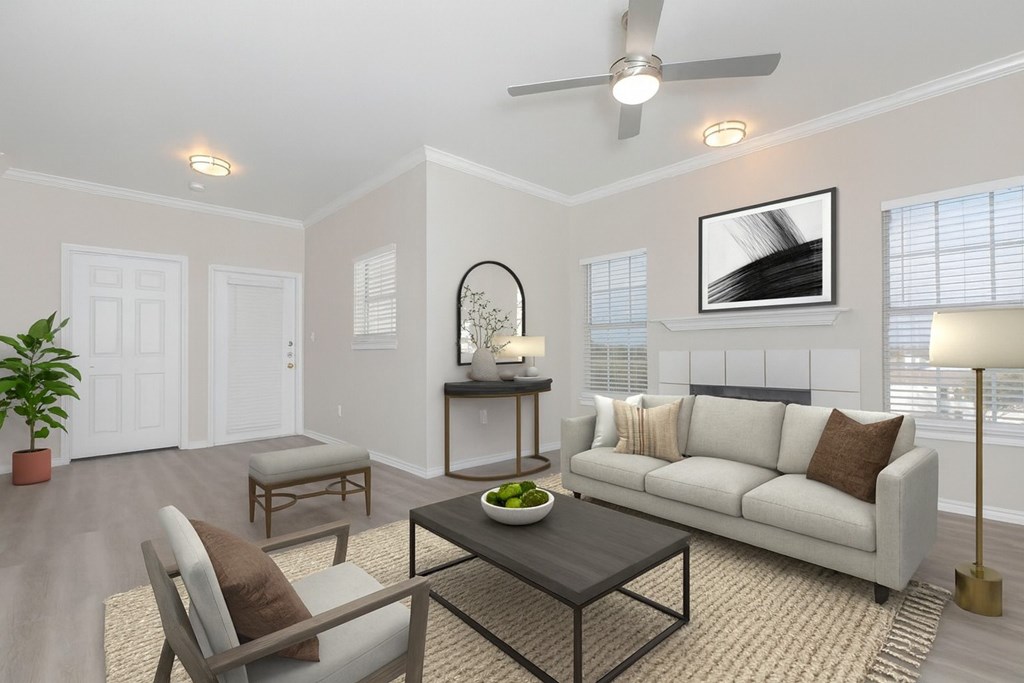 A living room with a white couch, a coffee table, and a potted plant.