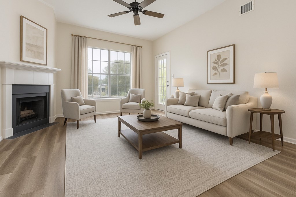 A living room with a fireplace, two chairs, a couch, a coffee table, and a ceiling fan.