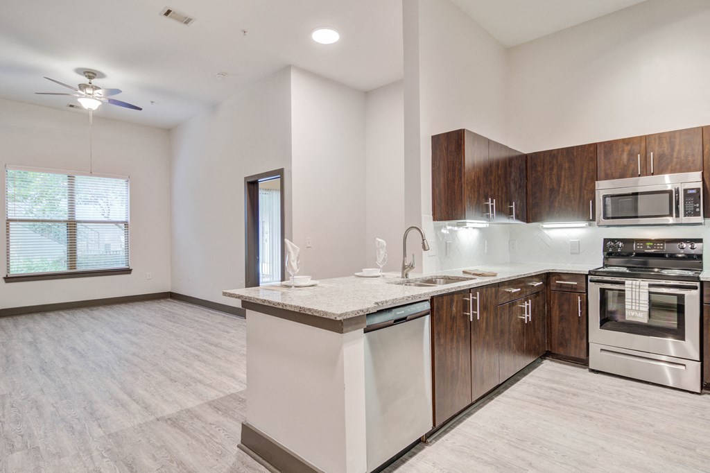 an empty kitchen with an island and stainless steel appliances