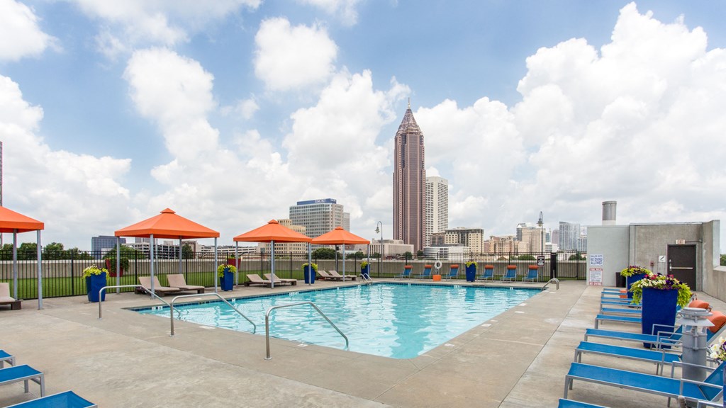 a swimming pool on the roof of a building with the city in the background