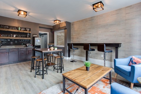 a living room with a bar and a dining area with chairs and tables