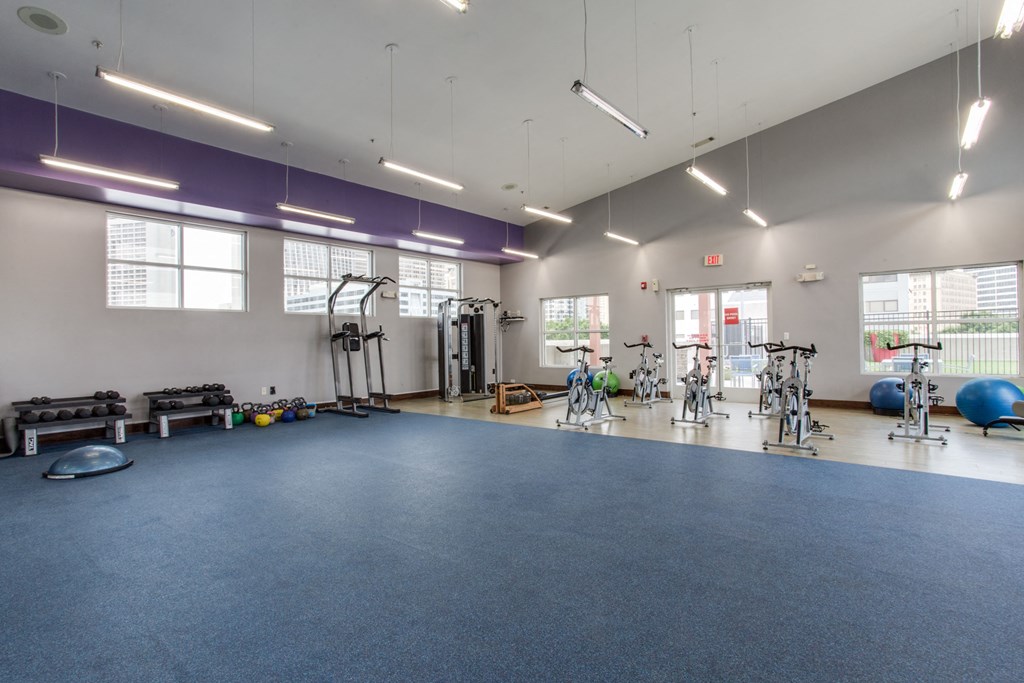 a large gym with exercise equipment and a blue floor