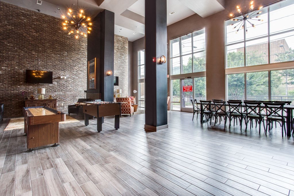 a large lobby with tables and chairs and large windows