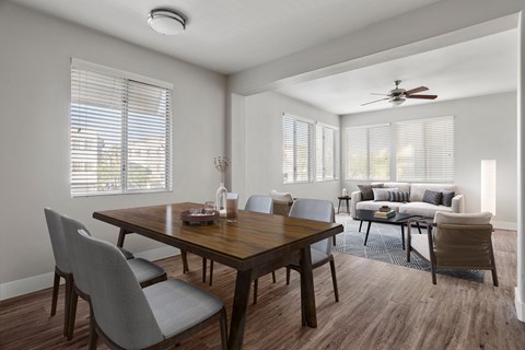 A dining room with a wooden table and grey chairs.