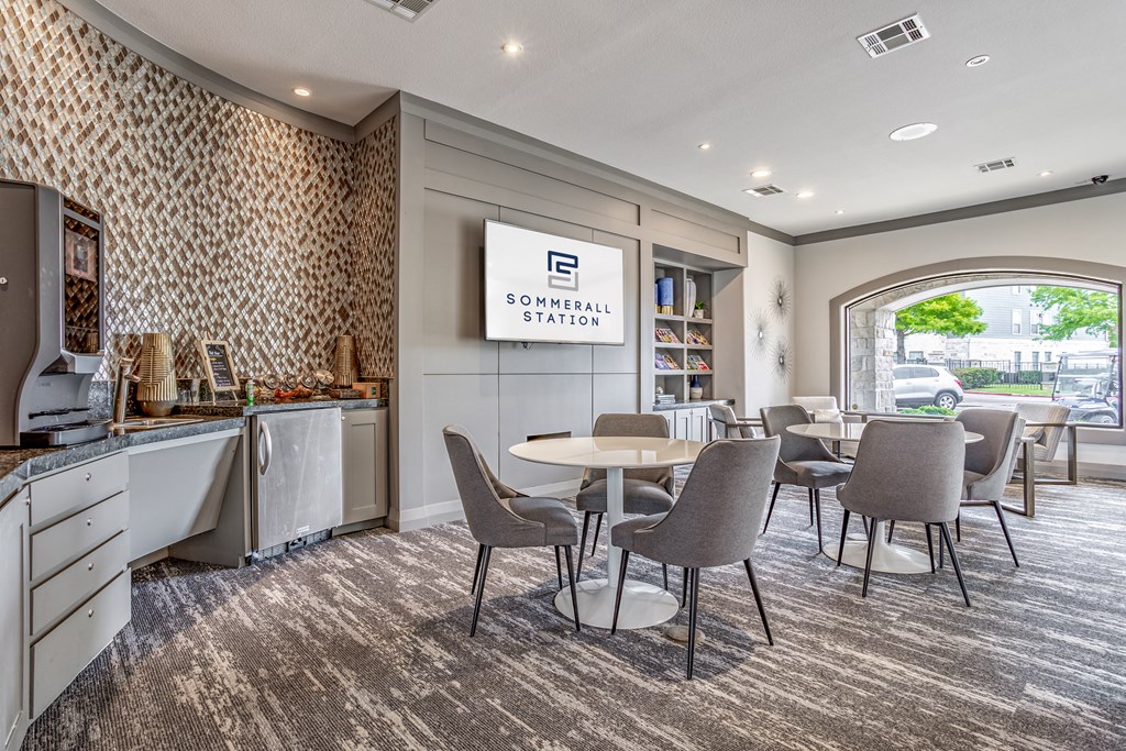a communal room with tables and chairs and a television